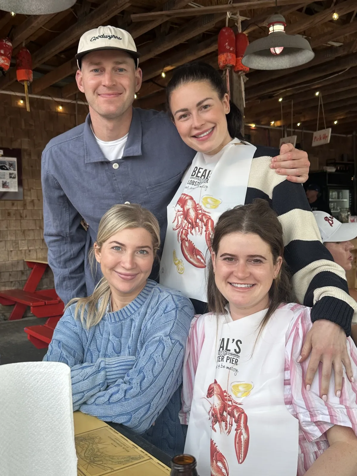 Molly with family and friends wearing lobster bibs at Beal's Lobster Pier in Maine