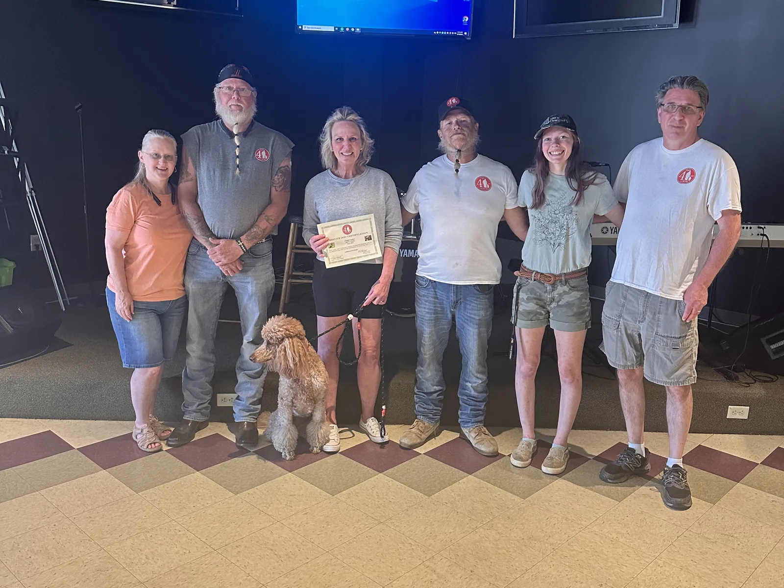 Ruby with Gianna and her team of trainers holding a certificate on graduation day